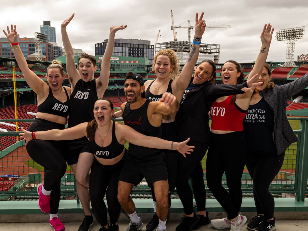 Riders from Rev’d Cycling pose for a group photo outside at Fenway Park after a PMC Winter Cycle session